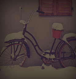 A cruiser bike with a front basket parked in the snow