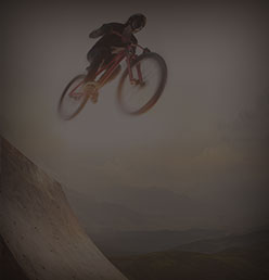 A mountain biker catching air on a ridgeline trail